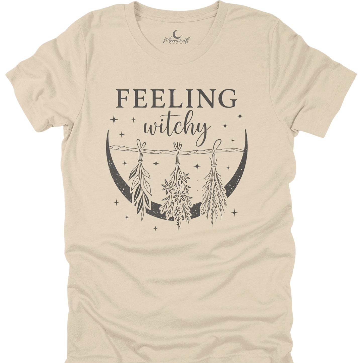 Beige t-shirt with 'Feeling witchy' text and moon design on a white background