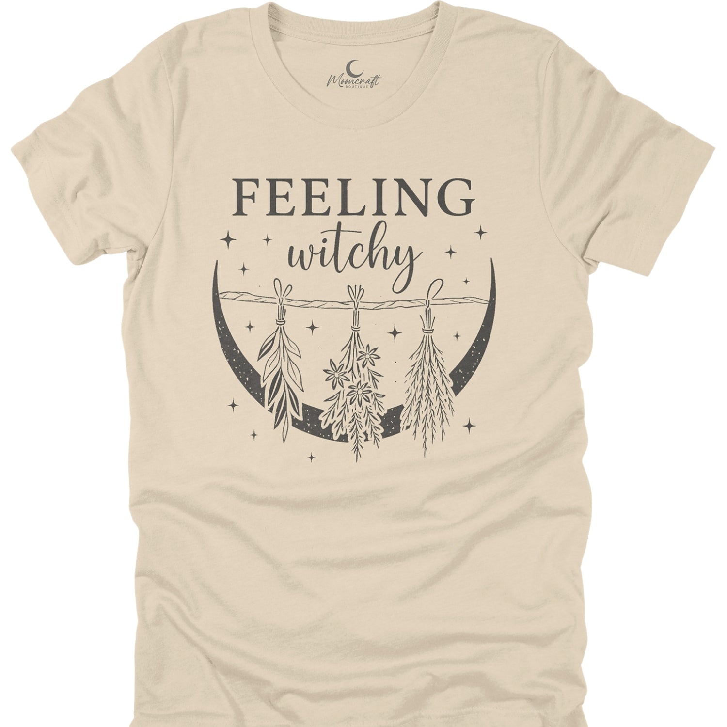 Beige t-shirt with 'Feeling witchy' text and moon design on a white background