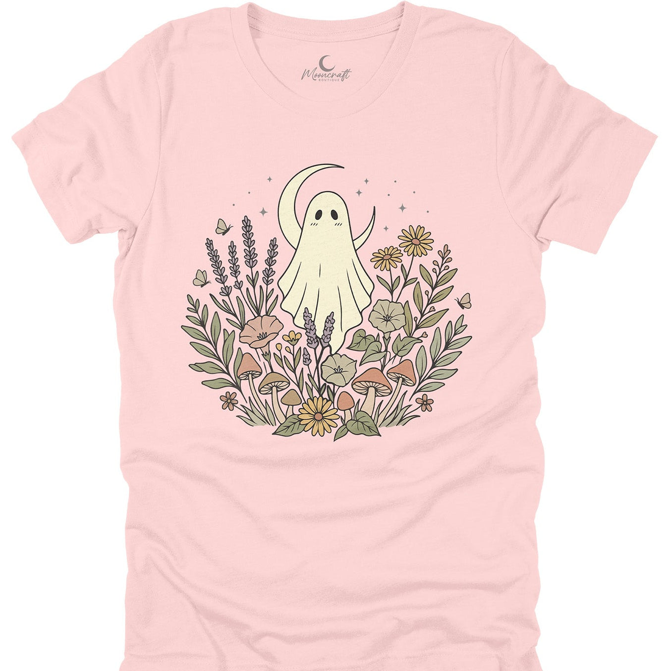 A light pink short-sleeve t-shirt with a central graphic of a cute cartoon ghost surrounded by wildflowers, a crescent moon, and small butterflies. The brand name 'Peachy Soft' is printed inside the collar.