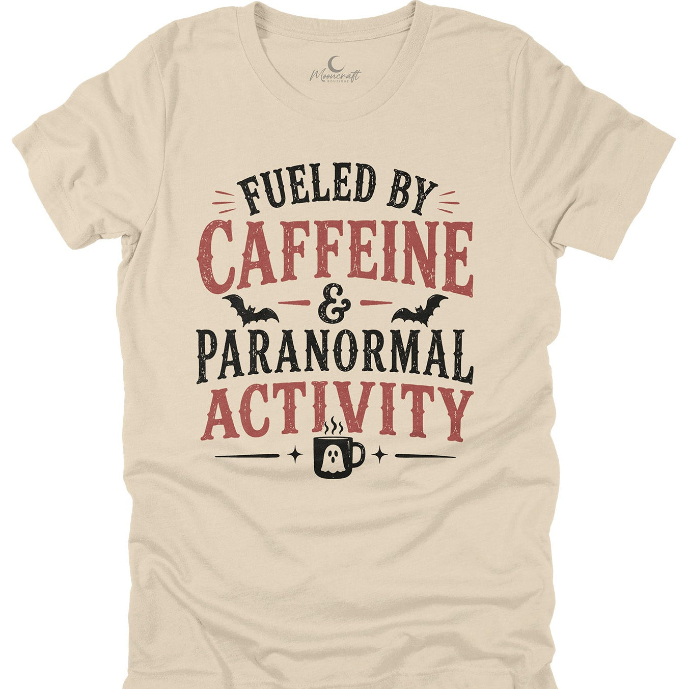 Beige t-shirt with 'Fueled by Caffeine & Paranormal Activity' text design on a white background