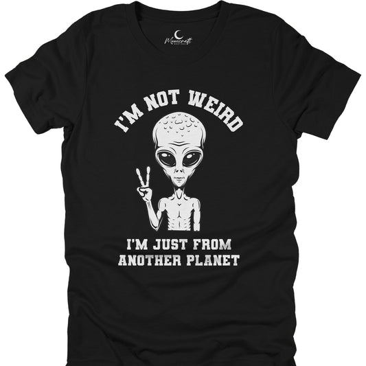 Black t-shirt with alien graphic and text 'I'm not weird, I'm just from another planet' on a white background.