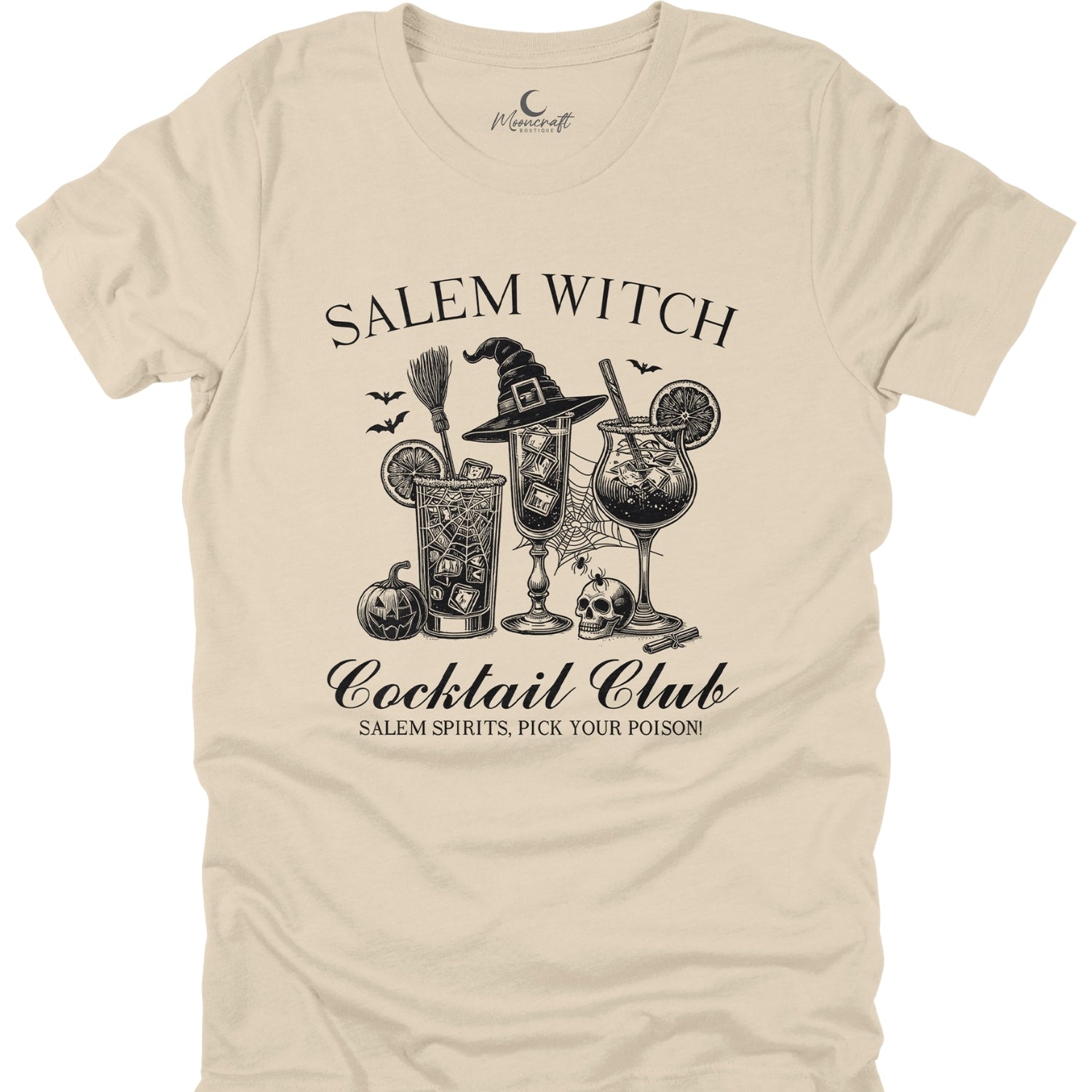 Beige t-shirt with black graphic design of a witch, broomstick, and cocktails on a white background