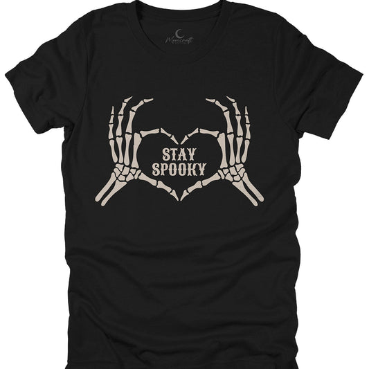 A black short-sleeve t-shirt with a graphic of two skeletal hands forming a heart shape, with the words 'STAY SPOOKY' printed in the center. The shirt is shown flat against a solid white background.
