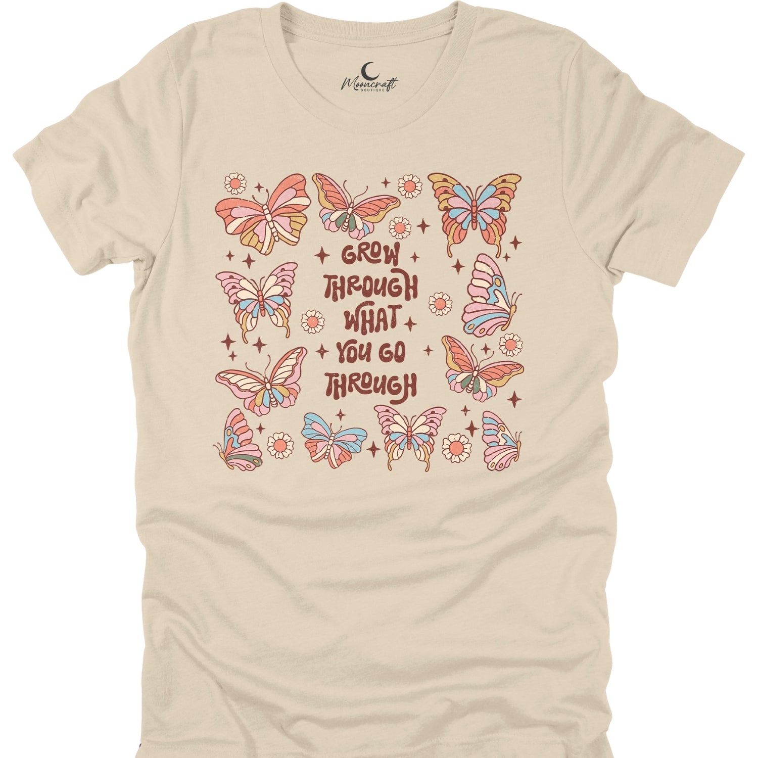 Beige t-shirt with colorful butterfly design and motivational quote on a white background